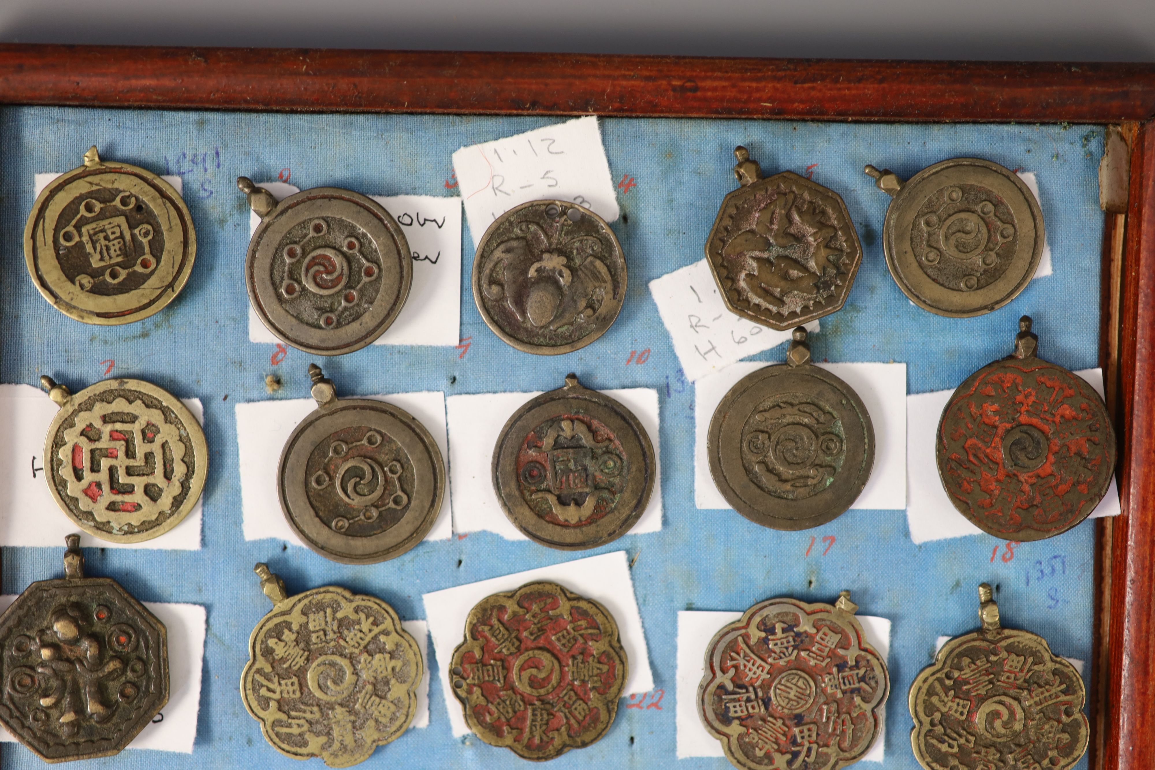 A group of 99 Korean bronze and metal amulets or charms, 19th/20th century